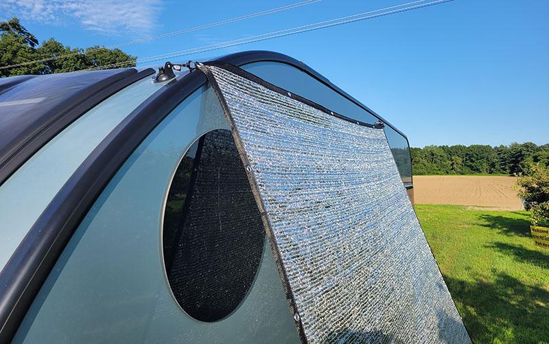 Side of camper showing the Aluminet shade cloth and Airhead tie-downs