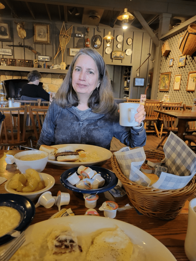 Tracy raises a cup of coffee at Cracker Barrel.